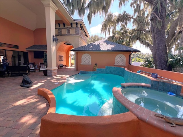 view of swimming pool with a patio and a pool with connected hot tub