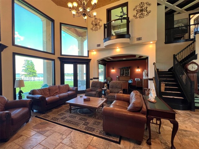 living room with a high ceiling, french doors, tile patterned flooring, and a chandelier