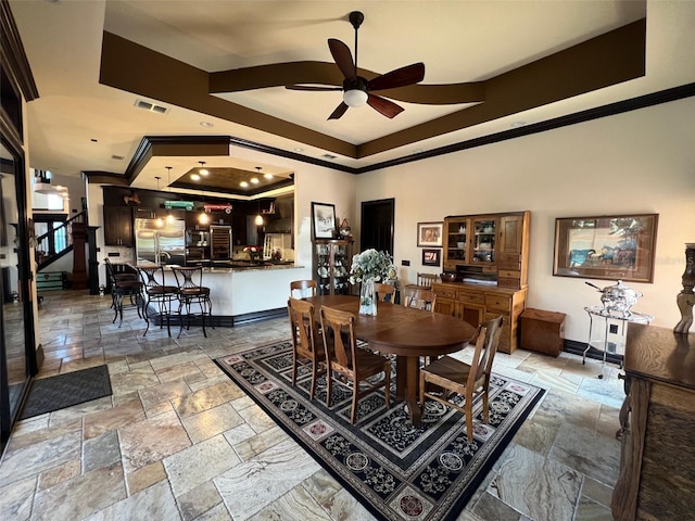 dining room with baseboards, a raised ceiling, visible vents, and stone tile floors