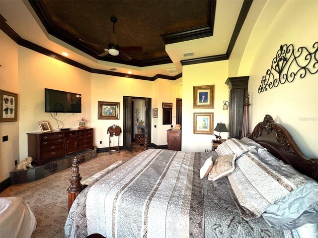 bedroom with a tray ceiling, ceiling fan, and ornamental molding