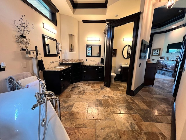 bathroom featuring vanity, crown molding, a raised ceiling, toilet, and stone tile flooring