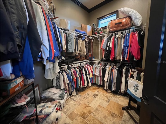 spacious closet featuring stone tile flooring