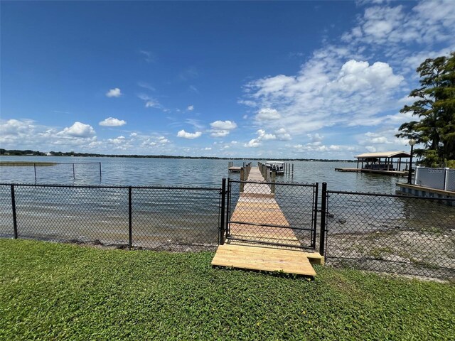 dock area featuring a lawn and a water view