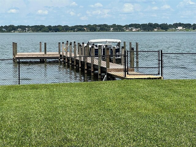 dock area with a yard and a water view