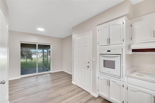 kitchen featuring white appliances, white cabinets, and light hardwood / wood-style floors