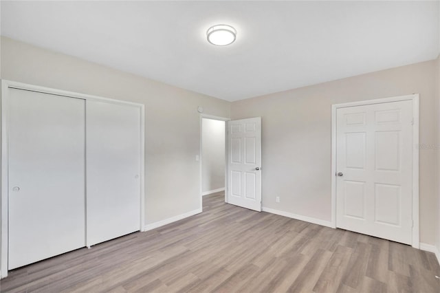 unfurnished bedroom featuring a closet and light hardwood / wood-style floors