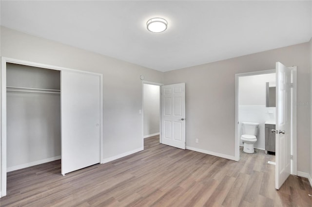 unfurnished bedroom with light hardwood / wood-style flooring, ensuite bathroom, and a closet