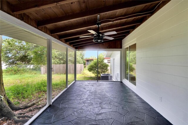 unfurnished sunroom featuring lofted ceiling with beams, ceiling fan, and wood ceiling