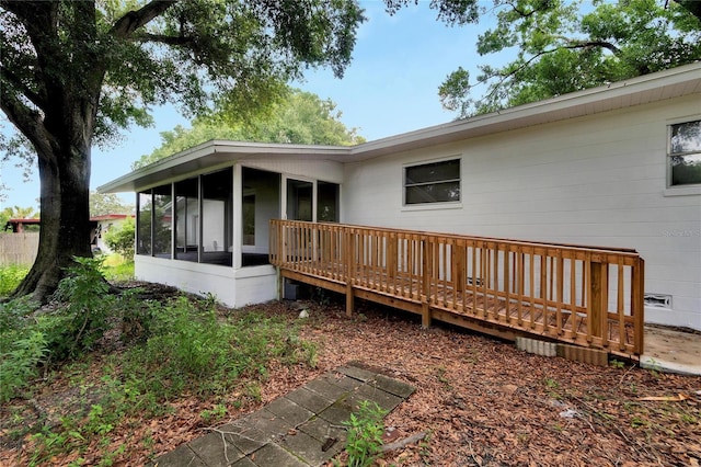 back of house featuring a sunroom and a deck