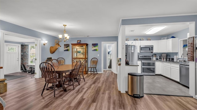 dining space with baseboards, a chandelier, and wood finished floors