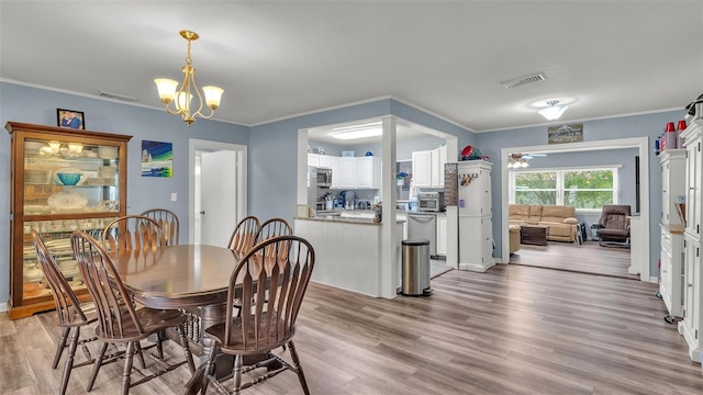 dining area featuring crown molding, visible vents, and light wood-style floors