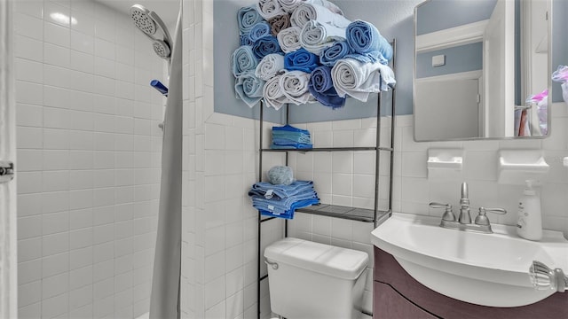 full bath featuring a shower with shower curtain, a sink, tile walls, and toilet