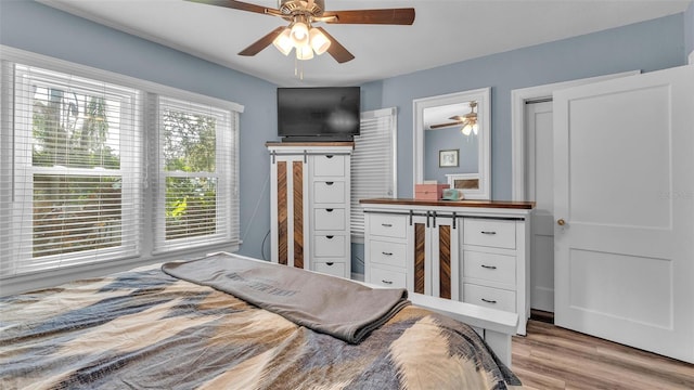 bedroom with light wood-style flooring and a ceiling fan