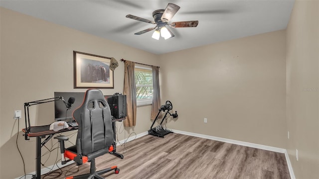 interior space featuring ceiling fan, baseboards, and wood finished floors