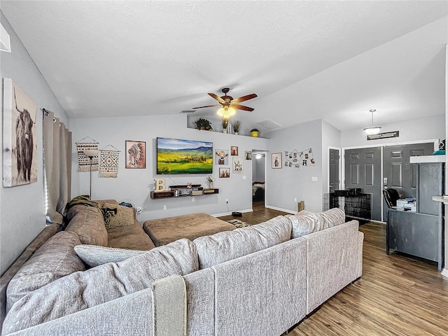 living room with ceiling fan, hardwood / wood-style floors, and vaulted ceiling