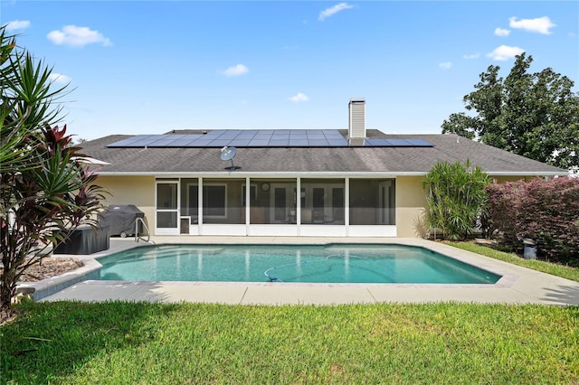 view of pool with a sunroom, grilling area, and a lawn