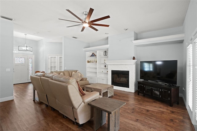 living room featuring ceiling fan with notable chandelier, dark hardwood / wood-style flooring, and vaulted ceiling