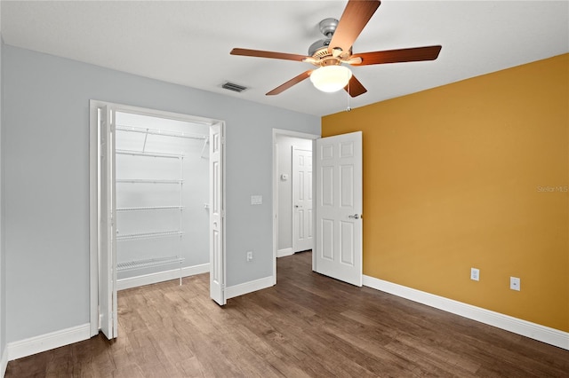 unfurnished bedroom with hardwood / wood-style flooring, ceiling fan, and a closet