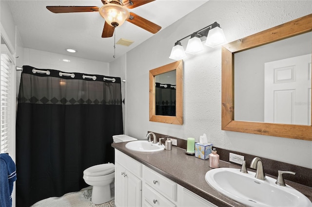 bathroom featuring ceiling fan, toilet, vanity, and walk in shower