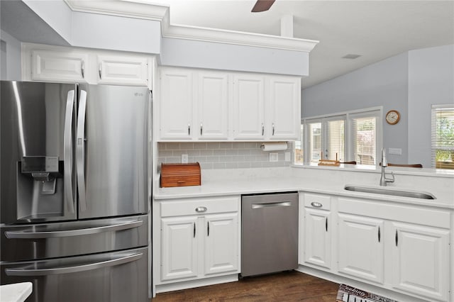 kitchen featuring white cabinetry, sink, dark wood-type flooring, stainless steel appliances, and tasteful backsplash