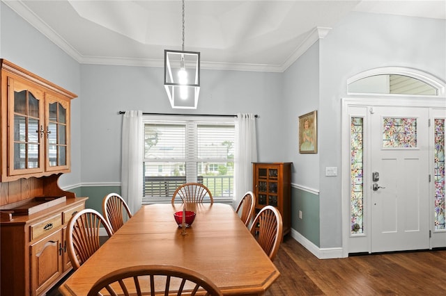 dining space featuring a tray ceiling, dark hardwood / wood-style floors, and ornamental molding