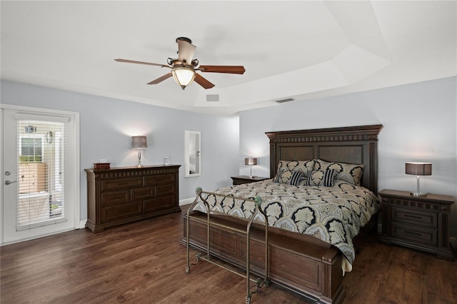 bedroom featuring a raised ceiling, access to exterior, ceiling fan, and dark hardwood / wood-style flooring