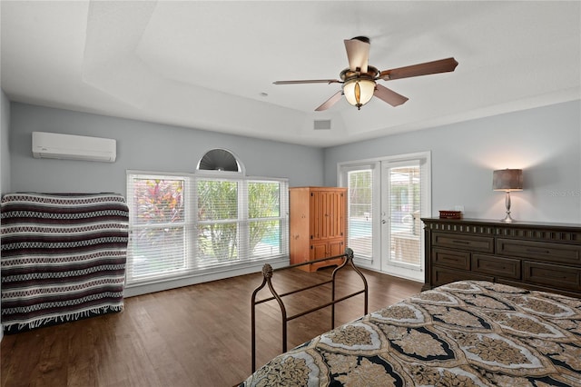 bedroom with a wall mounted air conditioner, access to outside, french doors, a raised ceiling, and ceiling fan