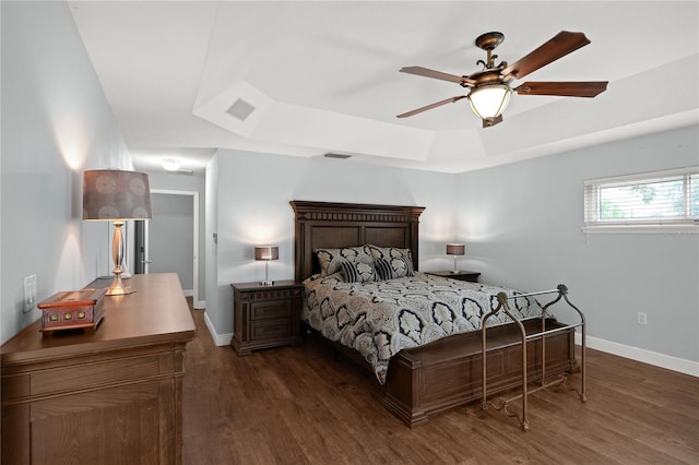 bedroom with a raised ceiling, ceiling fan, and dark hardwood / wood-style flooring