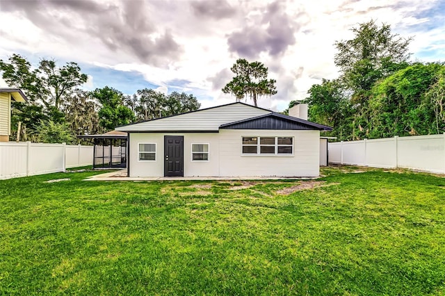 rear view of house featuring a lawn