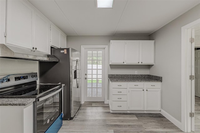 kitchen with light hardwood / wood-style flooring, stainless steel appliances, white cabinetry, and dark stone counters