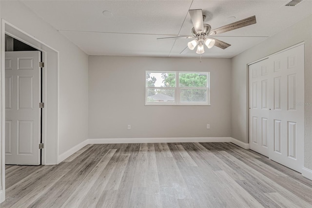 unfurnished bedroom featuring light hardwood / wood-style flooring, a closet, and ceiling fan