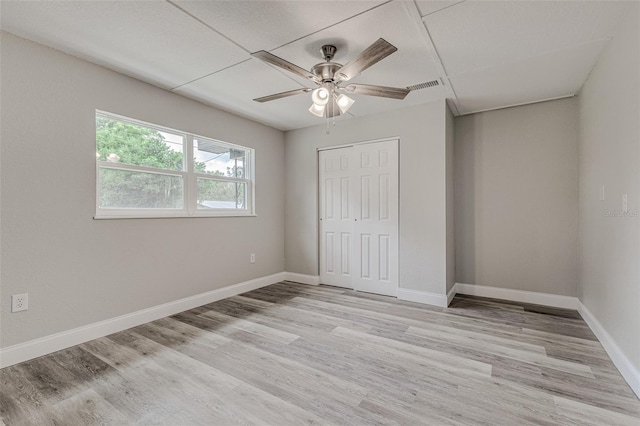 unfurnished bedroom with a closet, light wood-type flooring, and ceiling fan