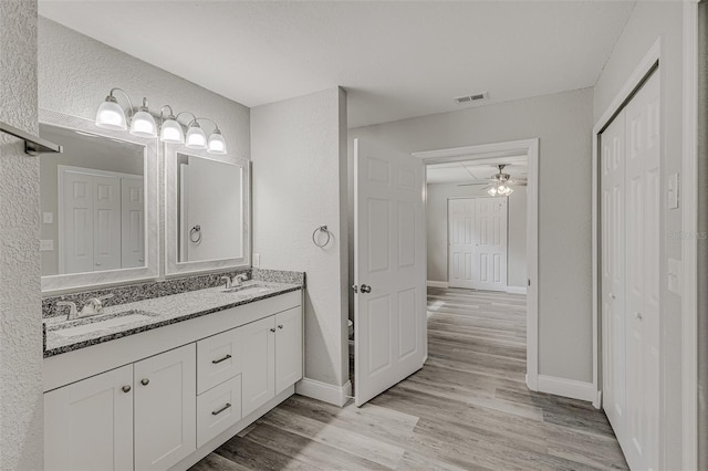 bathroom featuring ceiling fan, vanity, and wood-type flooring