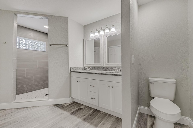 bathroom featuring hardwood / wood-style floors, a shower, vanity, and toilet