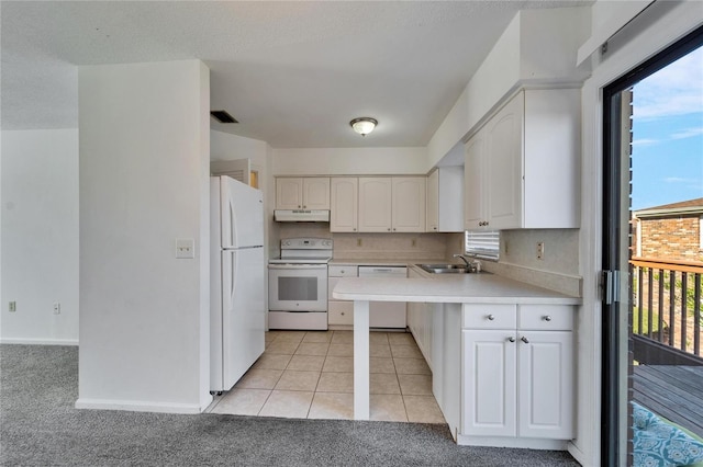 kitchen featuring white appliances, white cabinets, sink, light tile patterned floors, and kitchen peninsula