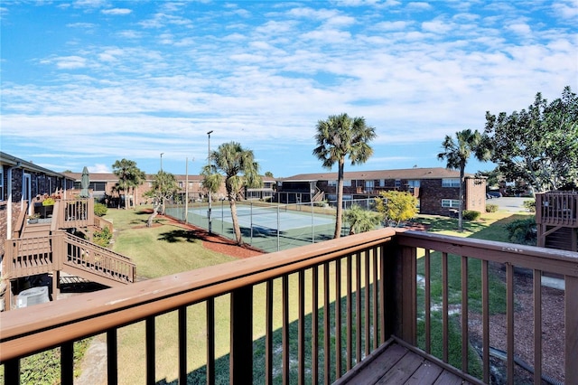 wooden terrace with a yard and tennis court