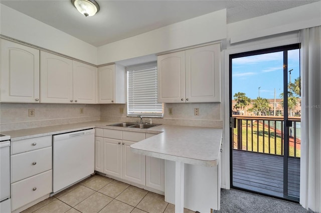 kitchen with dishwasher, sink, light tile patterned floors, backsplash, and white cabinets