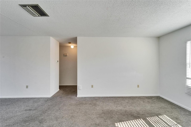 spare room with carpet and a textured ceiling