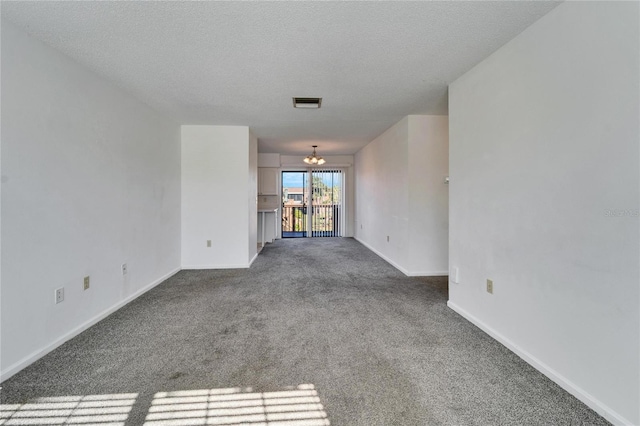 unfurnished living room featuring carpet flooring, a textured ceiling, and a chandelier