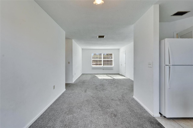 interior space featuring a textured ceiling and light colored carpet