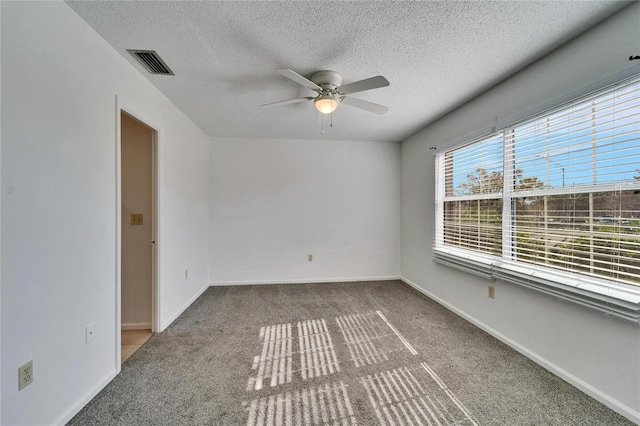 spare room with carpet flooring, a textured ceiling, and ceiling fan