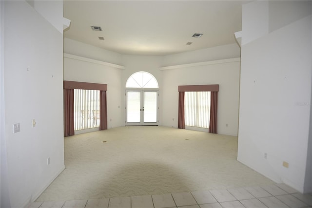 spare room with light colored carpet and french doors