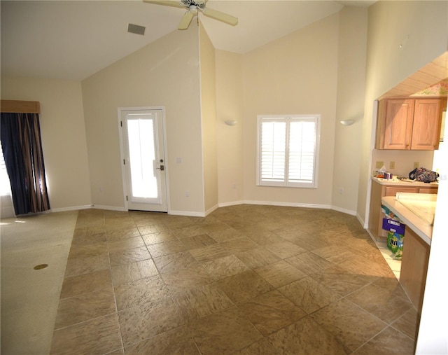 unfurnished living room featuring high vaulted ceiling and ceiling fan