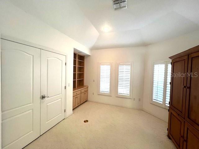 unfurnished bedroom with lofted ceiling and light colored carpet