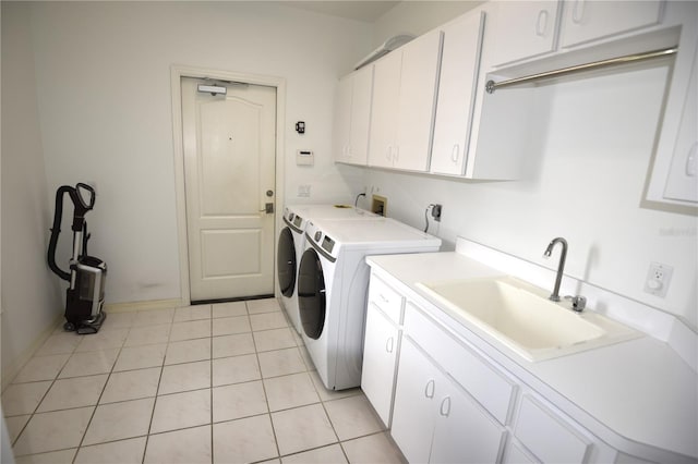 washroom featuring cabinets, washing machine and clothes dryer, light tile patterned floors, and sink