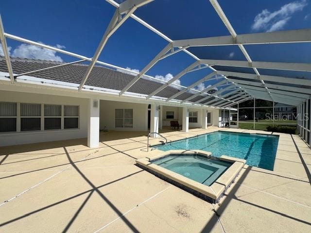 view of swimming pool featuring a lanai, a patio, and an in ground hot tub