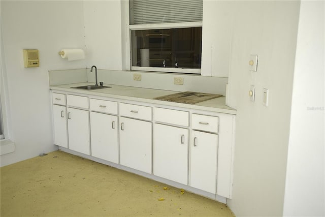 kitchen featuring white cabinetry and sink