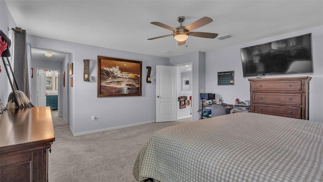 bedroom with light carpet, ceiling fan, and ensuite bath