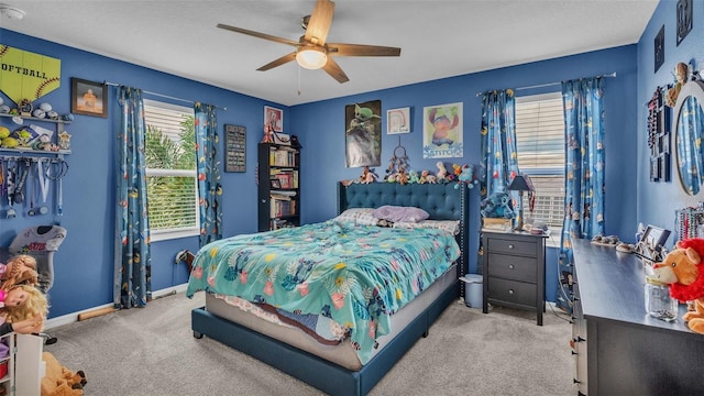 bedroom featuring light carpet, multiple windows, and ceiling fan