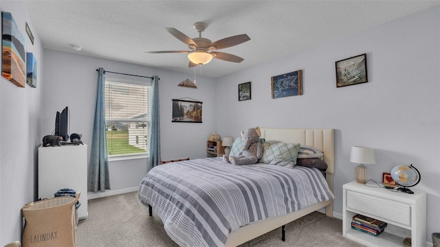 bedroom with light carpet, ceiling fan, and a textured ceiling